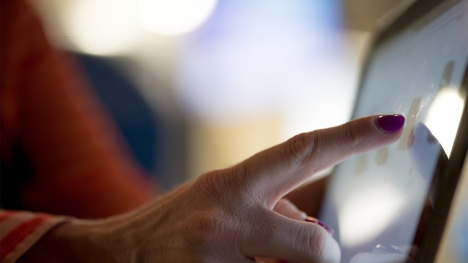 Women's hand pointing at ipad