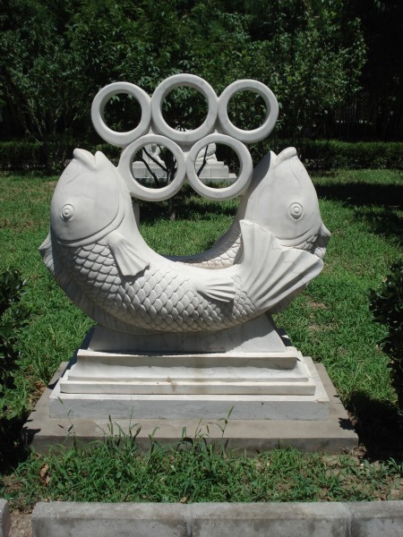 A statue outside the seminary which integrates the traditional symbolic uses of fish in Chinese culture and in Christianity, and look, the Olympic sign, too. 