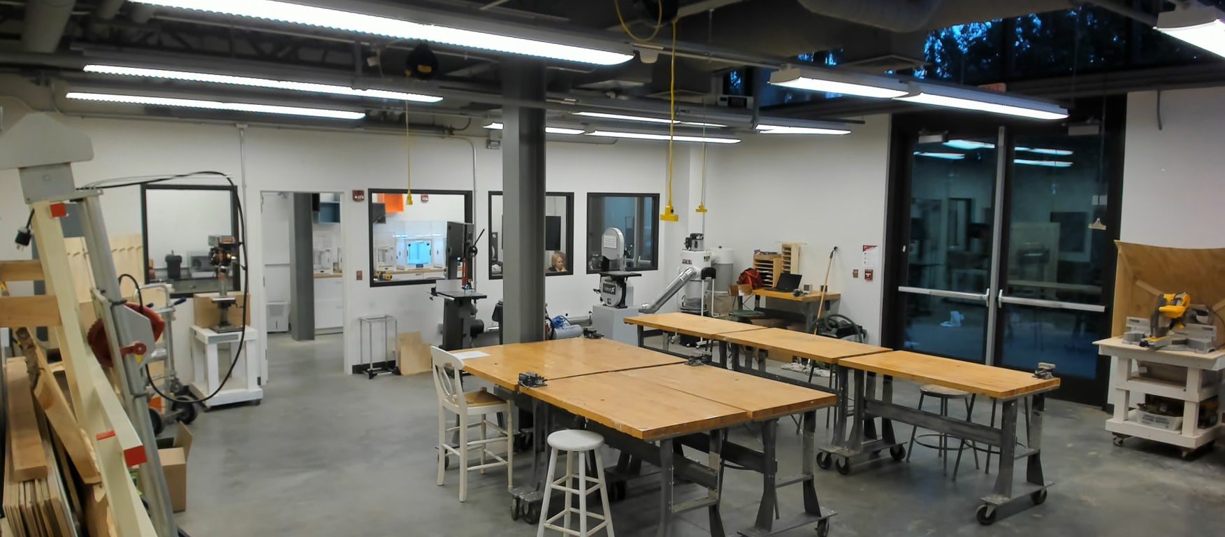 The MakerSpace interior with work tables and woodshop machines.