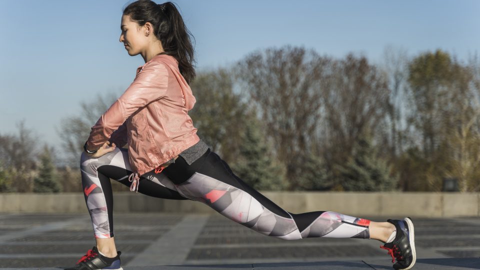 Fit young woman stretching outdoors
