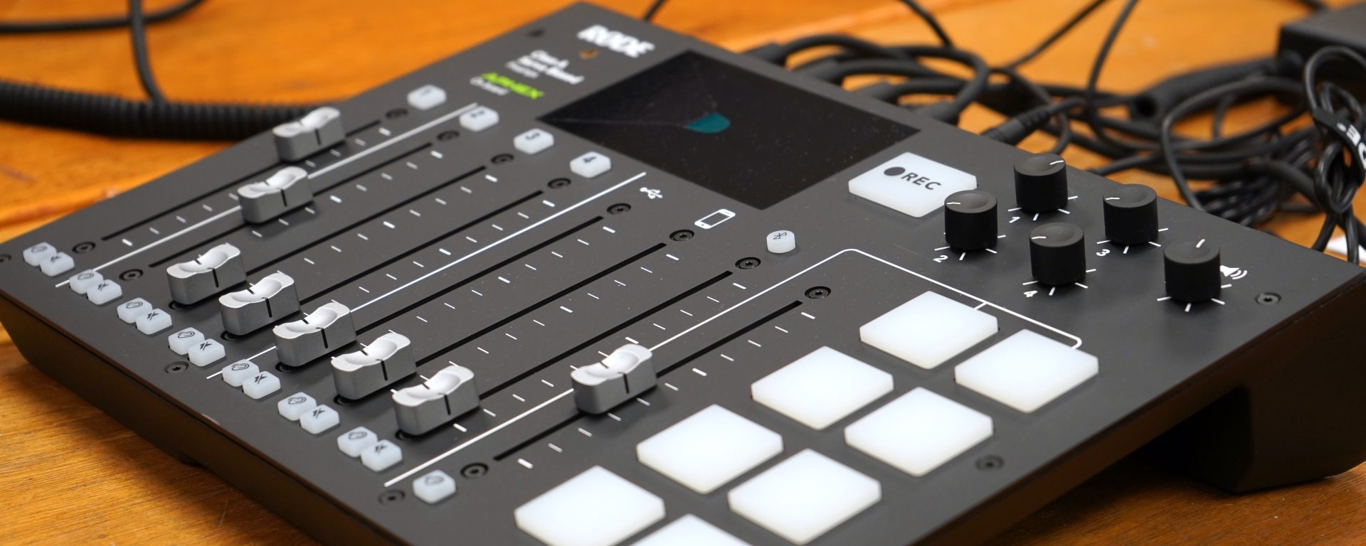 An audio mixer, with an array of sliding knobs and buttons.