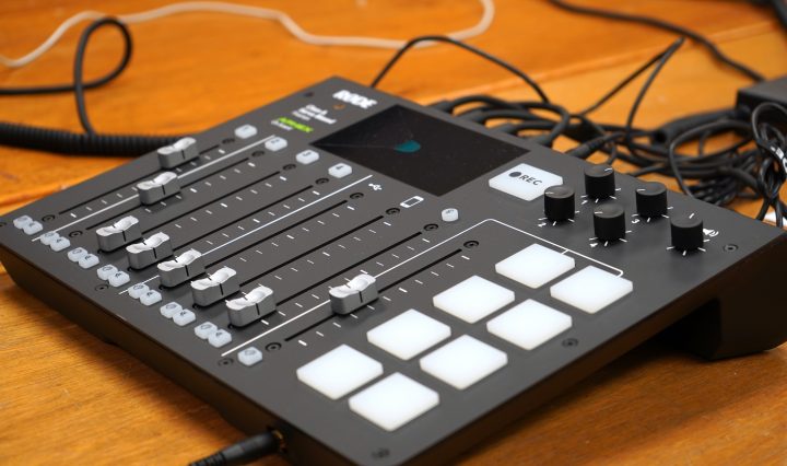 An audio mixer, with an array of sliding knobs and buttons.