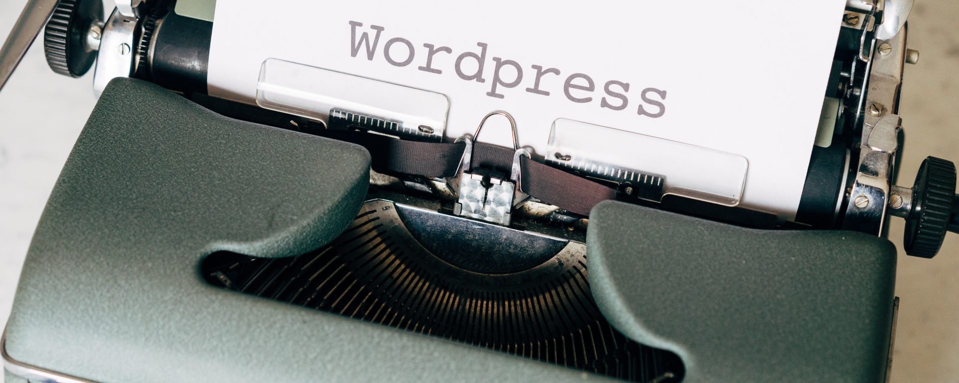 typewriter with the word WordPress typed on a piece of white paper