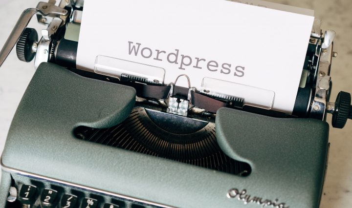 typewriter with the word WordPress typed on a piece of white paper