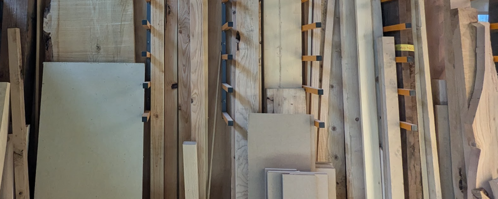 a broad shot of a wall rack holding wood materials of various types and sizes