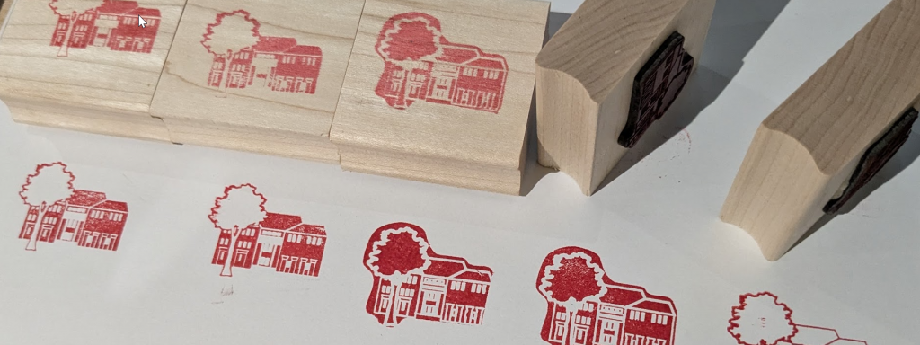 a close up of custom rubber and wood stamps with red prints of an icon of Swarthmore's McCabe Library