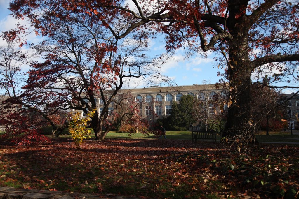 The exterior of Beardsley Hall sits in the background with fall foliage in the foreground. 